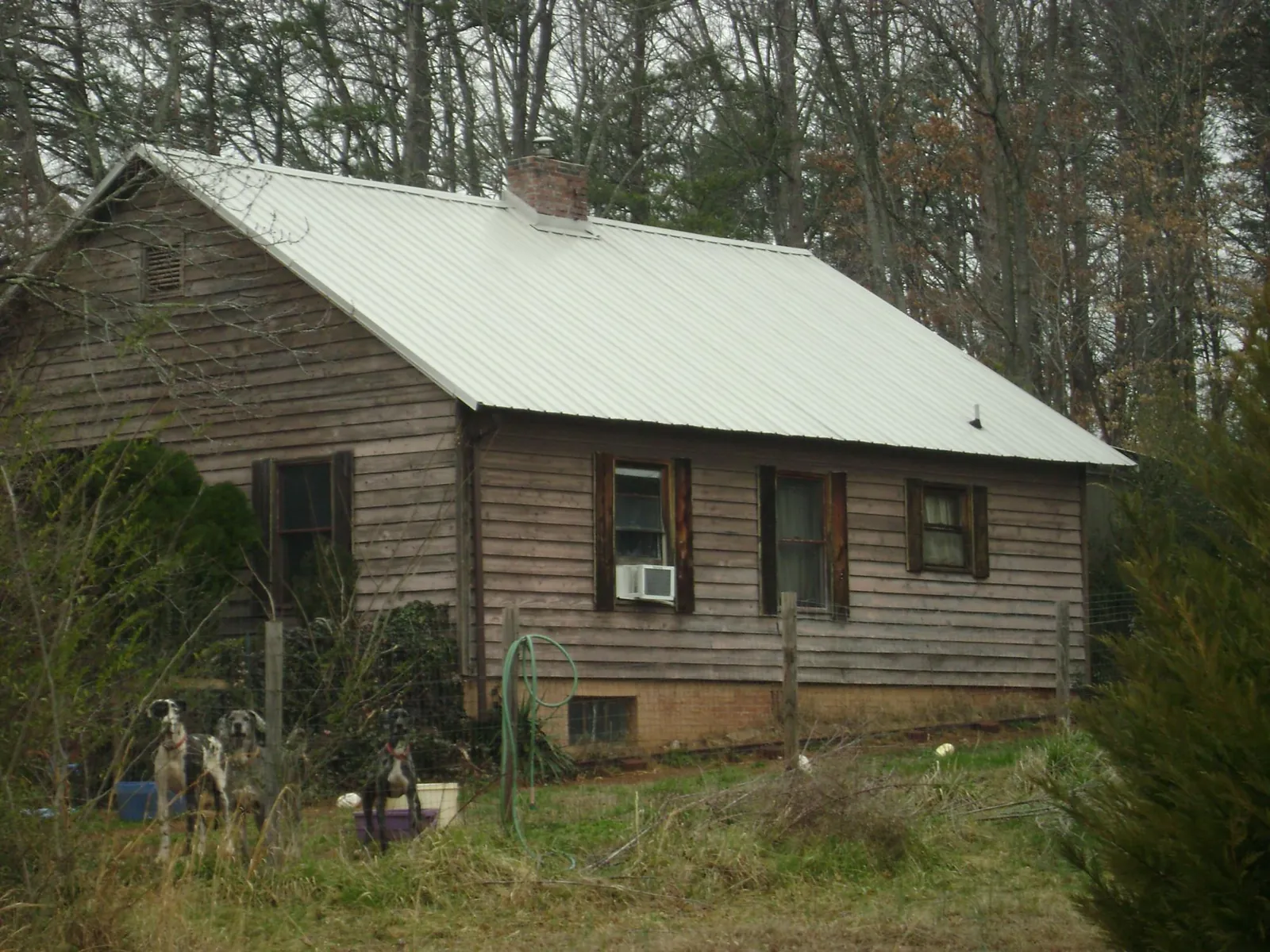 White metal roof on an old wood sided farmhouse, from a Metal Roof Installation job in Garland